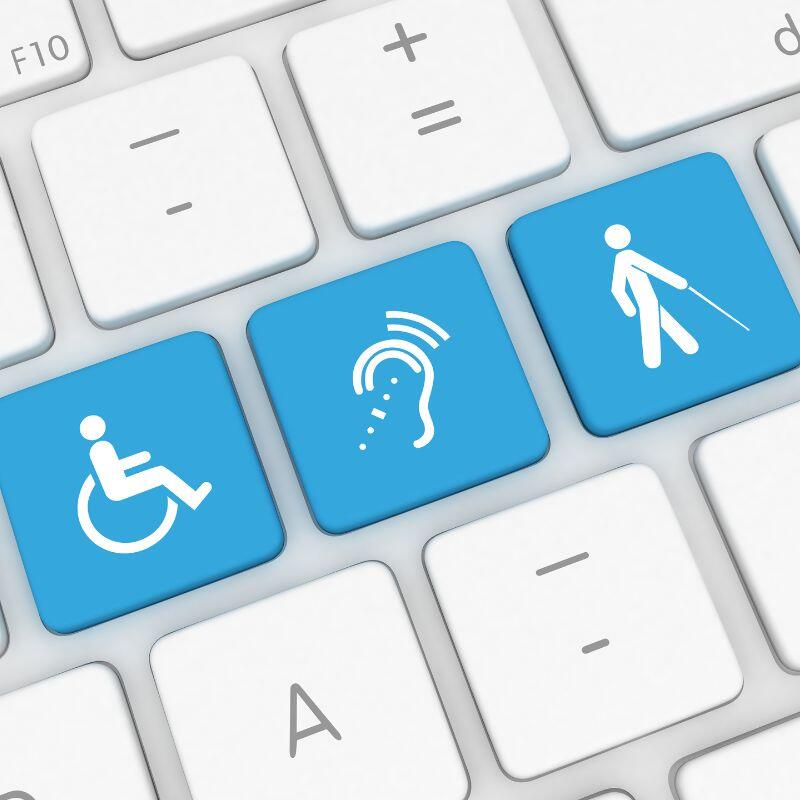 Auf einer Tastatur sind 3 Symbole eines Rollstuhls, einer Hörschädigung und einer Person mit Blindenstock in hellblau hinterlegt