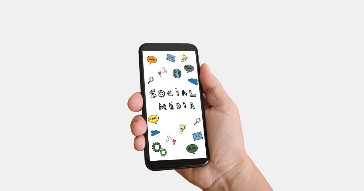 Ein Smartphone wird in der rechten Hand gehalten. Auf dem Display sind verschiedene Icons und Elemente aus dem Social Media Marketing abgebildet.