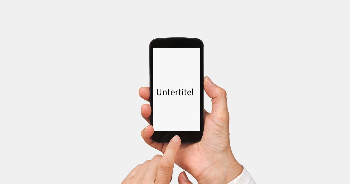Eine person hält ein Smartphone in der rechten Hand. Auf dem Display steht Untertitel geschrieben.